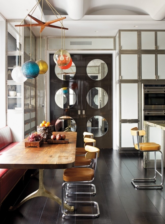 Стеклянные зеркальные двери гармонируют с металлическими элементами в интерьере этой кухни