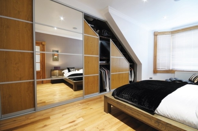 Встроенный шкаф с раздвижными дверцами в спальне, расположенной на мансарде
