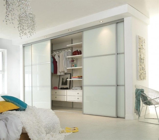Минималистский светлый шкаф с раздвижными дверями в  минималистской спальне