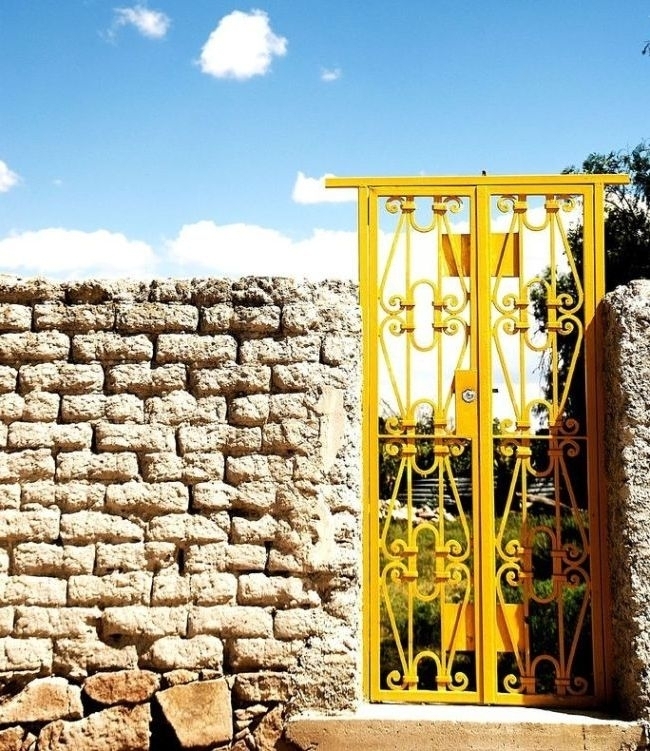 Кованые ворота прекрасно сочетаются с каменным забором